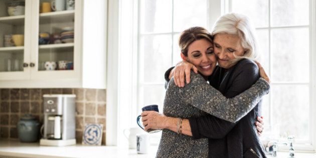 mother and daughter hugging in kitchen