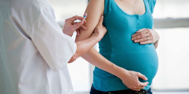 Pregnant woman receiving vaccination.