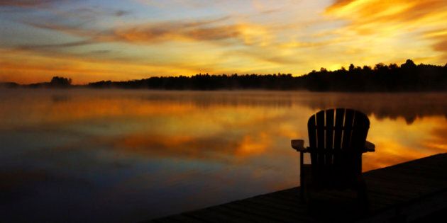 Adirondack chair on cottage deck at sunrise Sharbot Lake, Ontario, Canada