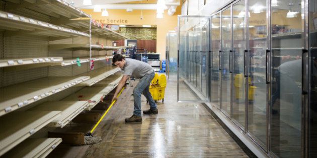 A crew member mops the inside of a grocery store after clearing all the expired food off the shelves as thousands of evacuees who fled a massive wildfire begin to trickle back to their homes in Fort McMurray, Alberta, Canada June 2, 2016. REUTERS/Topher Seguin
