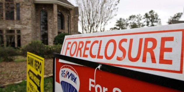 A bank repo and foreclosure for sale signs sit outside a foreclosed home Saturday, Jan. 10, 2009 in Houston. (AP Photo/David J. Phillip)