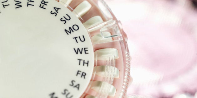 Close-up of birth control pills in two plastic tablet dispenser cases