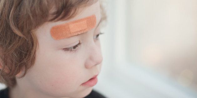 portrait of a boy with a band aid in his forehead