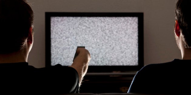 Two men watching static on television