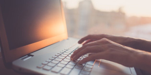 Woman typing on laptop at workplace working in home office hand keyboard