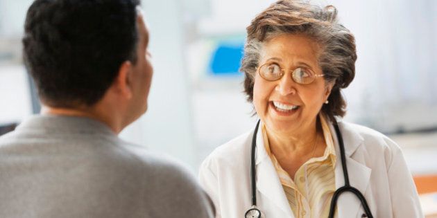 Senior Hispanic female doctor talking to patient