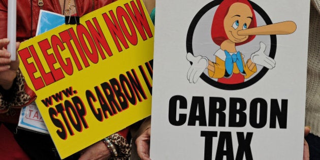 Protesters hold placards during a rally in Sydney on July 1, 2011 against Australian Prime Minister Julia Gillard's plans to introduce a carbon tax. A powerful industry alliance is preparing to launch a multi-million dollar campaign designed to derail PM Julia Gillard's plans to price carbon, reports said July 1, 2011. AFP PHOTO / Greg WOOD (Photo credit should read GREG WOOD/AFP/Getty Images)