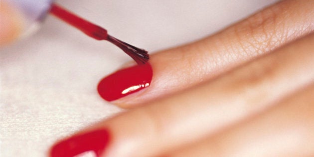 Close-up studio shot of woman applying nail polish