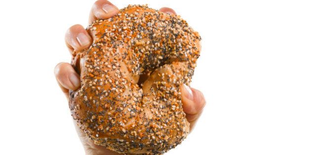 Woman holding a Wheat Everything Bagel in her hand