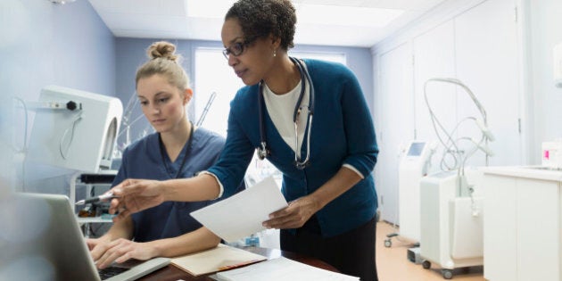 Doctor and nurse talking at laptop