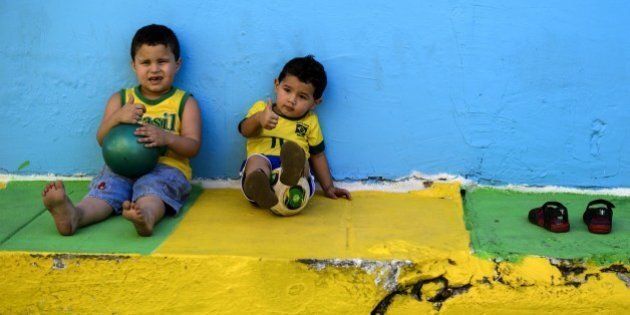 Young Brazilian children pose on a street decorated in the colours of the Brazilian national flag in a suburb next to The Arena Amazonia in Manaus on June 14, 1014, ahead of the England v Italy match of the 2014 FIFA World Cup. AFP PHOTO / FABRICE COFFRINI (Photo credit should read FABRICE COFFRINI/AFP/Getty Images)