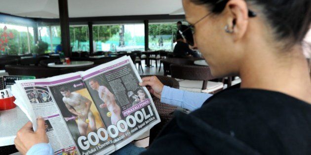 A woman views the daily newspaper '24 Sata' (24 Hours) showing photos of several Croatia's players naked by their swimming pool in Brazil, at a bar in downtown Zagreb, Croatia, on June 16, 2014. Croatia international striker Ivica Olic slammed local media for the 'shameful' publishing of photographs which showed teammates swimming naked at their World Cup base in Brazil, a local paper reported on June 16. Publishing of the photos sparked outrage from the players who decided to boycott all media duties leaving coach Niko Kovac to explain their decision. 'Goli' means 'Naked' in Croatian. AFP PHOTO (Photo credit should read STR/AFP/Getty Images)