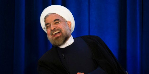 Iranian President Hassan Rouhani laughs during a address and discussion hosted by the Asia Society and the Council on Foreign Relations at the Hilton Hotel in midtown Manhattan, Thursday, Sept. 26, 2013, in New York. (AP Photo/John Minchillo)