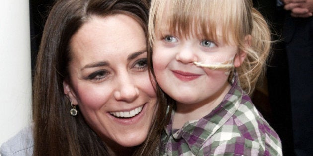 Britain's Catherine, the Duchess Of Cambridge, hugs Demi-Leigh Armstrong, aged 5, during a visit to the Shooting Star House Children's Hospice in Hampton, Middlesex, on December 6, 2013. AFP PHOTO/POOL/BRADLEY PAGE (Photo credit should read BRADLEY PAGE/AFP/Getty Images)