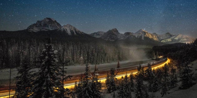 Cargo train passes through the famous 'Morant's Curve' offering a beautiful view of the frozen Bow River...