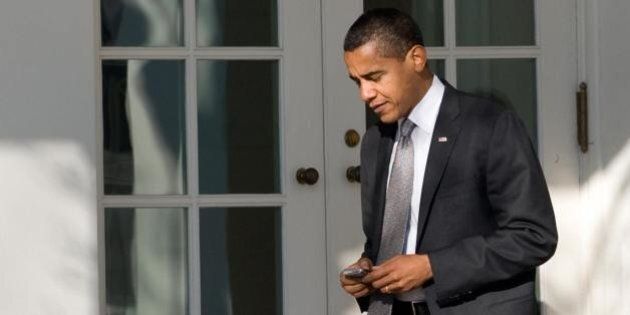 US President Barack Obama uses his BlackBerry or similar device as he walks to the Oval Office after returning to the White House in Washington, DC, January 29, 2009, after attending a performance at his daughter's school. AFP PHOTO / Saul LOEB (Photo credit should read SAUL LOEB/AFP/Getty Images)