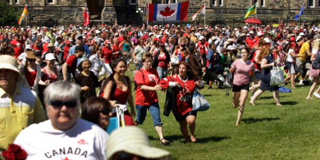 Spectators run for a position to see Prince William and Kate, the Duke and Duchess of Cambridge at a Canada Day celebration on Parliament Hill in Ottawa, Canada Friday, July 1, 2011. (AP Photo/Charlie Riedel)