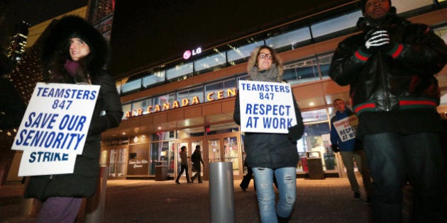 TORONTO, ON- DECEMBER 13 - Members of Teamsters 847 picket in Maple Leaf Square between Real Sports Bar and Grill and Gate 6 before the Toronto Raptors play the Philadelphia 76ers at Air Canada Centre in Toronto. The strike affects 600 workers, including the kitchen, housekeeping, conversion crew, warehouse and bartenders. December 13, 2013. (Steve Russell/Toronto Star via Getty Images)