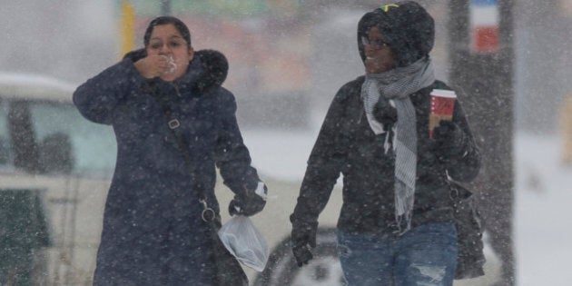 TORONTO - DECEMBER 14 - Catalina Muggli (left) tastes a bit of freshly fallen snow as she and Janice Deacon walk south on Kipling Avenue towards their job. Toronto hit by first snow storm of the year on December 14, 2013. Todays weather was largely a product of lake affect snow, with the larger system expected to arrive overnight bringing anywhere from 10-25 cm of snow. (Rick Madonik/Toronto Star via Getty Images)