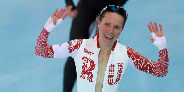 Bronze medallist Olga Graf of Russia celebrates with a wide open front of her skin suit after the women's 3,000-meter speedskating race at the Adler Arena Skating Center during the 2014 Winter Olympics, Sunday, Feb. 9, 2014, in Sochi, Russia. (AP Photo/Pavel Golovkin)