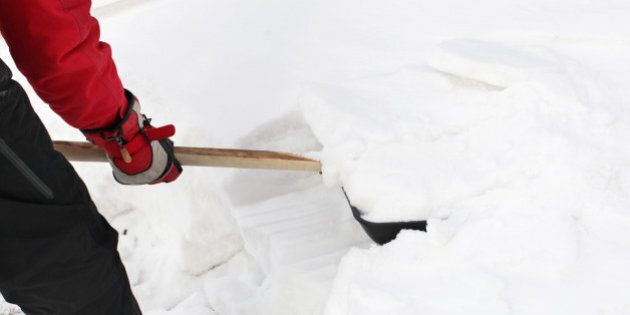 man snow cleaning by a shovel
