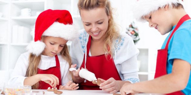 Family decorating christmas cookies together in the kitchen