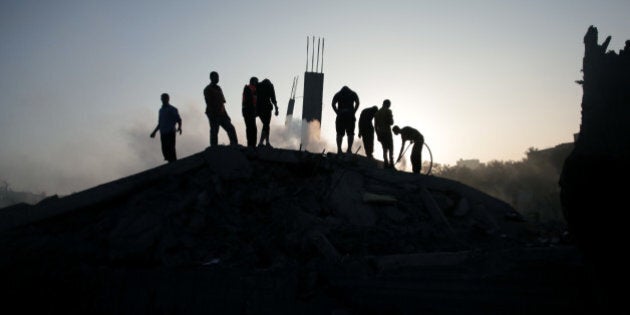 Palestinians try to salvage what they can of their belongings from the rubble of a house destroyed by an overnight Israeli airstrike in Gaza City Tuesday, July 8, 2014. Israel launched what could be a long-term offensive against the Hamas-ruled Gaza Strip on Tuesday, the military said, striking at least 50 sites in Gaza by air and sea and mobilizing troops for a possible ground invasion in order to quell rocket attacks on Israel. (AP Photo/Khalil Hamra)