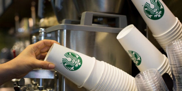 Barista Kim Jung Mi, a mother who had left the workforce seven years ago and is now employed by Starbucks Coffee Korea Co. under its 'returning-mom' program, takes a paper cup at one of the company's stores in Gimpo, South Korea, on Friday, March 7, 2014. Starbucks Korea's 'returning-mom' program is part of a drive to raise female participation in Asia's fourth-largest economy as the nation's first female leader, President Park Geun Hye, tries to counter the effects of an aging population. Photographer: SeongJoon Cho/Bloomberg via Getty Images