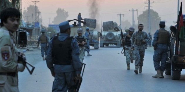 Afghan policemen and security forces arrive at the scene after an attack by Taliban militants on the Afghan intelligence service office in Jalalabad on August 30,2014. Taliban militants August 30 attacked an Afghan intelligence service office in the eastern city of Jalalabad, killing at least three people in a bomb and gun assault, officials said. AFP PHOTO/Noorullah Shirzada (Photo credit should read Noorullah Shirzada/AFP/Getty Images)