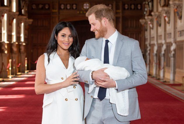 Meghan Markle, Duchess of Sussex and Prince Harry, Duke of Sussex, pose for a photo with their newborn baby son, Archie Harrison Mountbatten-Windsor, in St George's Hall at Windsor Castle in Windsor, west of London on May 8, 2019.