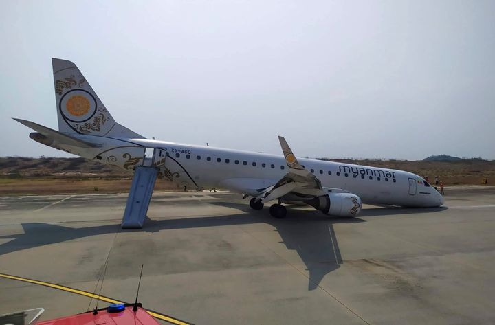 A Myanmar National Airlines plane sits on the runway at Mandalay International airport on Sunday after its pilot was forced to land the aircraft without its front wheels deploying,