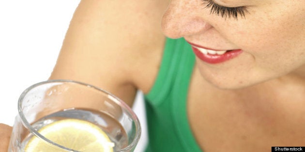 young woman drinking glass of...