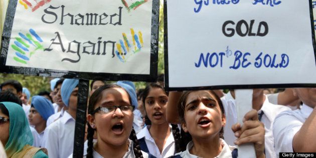 Indian schoolchildren and teachers shout slogans as they carry placards during a demonstration against the rape of a five-year old girl near Parliament in New Delhi on April 23, 2013. Indian police arrested a second man over the kidnap and rape of a five-year-old girl in New Delhi, but officers faced protests and a hail of criticism over their insensitive handling of the case. AFP PHOTO/RAVEENDRAN (Photo credit should read RAVEENDRAN/AFP/Getty Images)