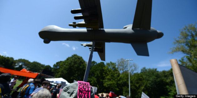 Protestors against the use of drone strikes by the US military hold a model of a drone aircraft during the 'March On Wall Street South' rally in Charlotte, North Carolina, ahead of the Democratic National Convention, on September 2, 2012. Hundreds of people chanting slogans and carrying signs against and for an assortment of different causes marched through the city to protest what they said was seedy corporate influence on politics. AFP PHOTO / ROBYN BECK (Photo credit should read ROBYN BECK/AFP/GettyImages)