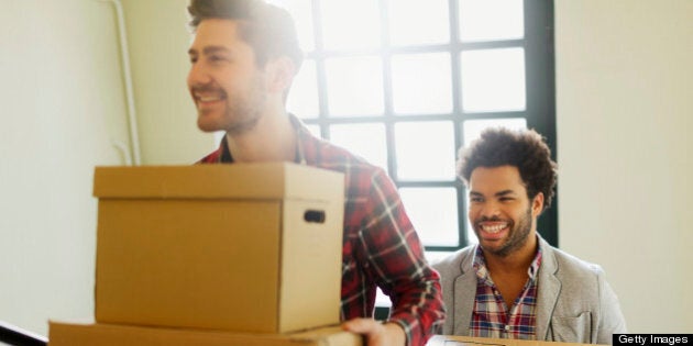 Young entrepreneurs moving into a new Office. The two men are carrying boxes into the new Office.