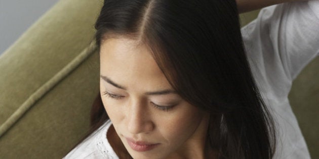 Asian woman sitting on sofa