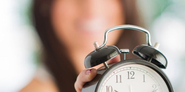 woman holding clock indoors