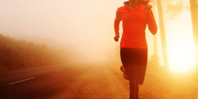 Athlete running on the road in morning sunrise training for marathon and fitness. Healthy active lifestyle latino woman exercising outdoors.