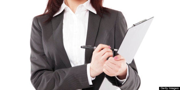 Young attractive Asian businesswoman taking writing on clipboard and looking at camera, isolated on white background.