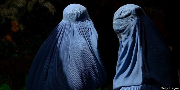 Burqa-clad Afghan women shop in a busy market in Herat early April 21, 2013. Afghanistan has made some progress in using the law to protect women against violence but many still suffer horrific abuse despite 11 years of Western intervention, a UN report on December 2012 showed. AFP PHOTO/ SHAH Marai (Photo credit should read SHAH MARAI/AFP/Getty Images)