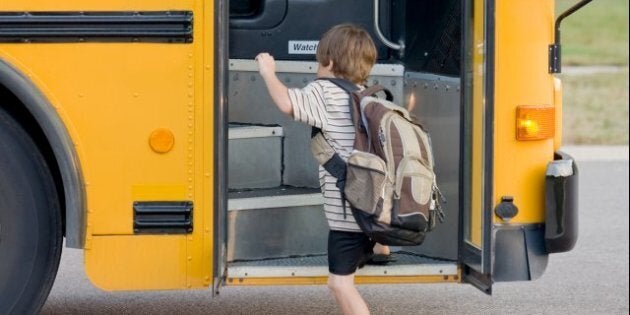 little boy getting on bus