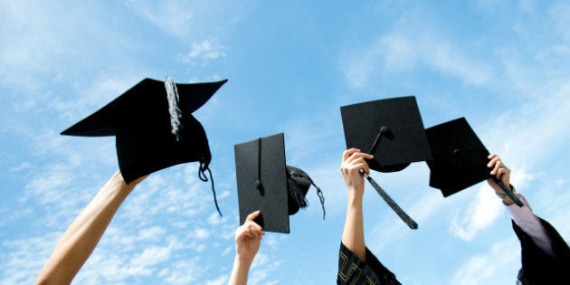 many hand holding graduation...