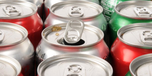 A single opened soft drink can in rows of drinks