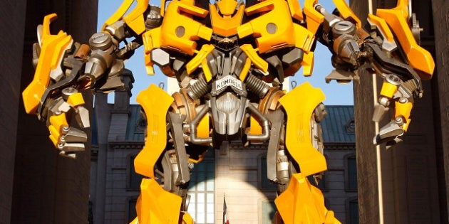 LAS VEGAS - MARCH 30: Tourists walk behind a large model of the Bumblebee character from the movie 'Transformers' at the Paris Las Vegas during ShoWest, the official convention of the National Association of Theatre Owners, March 30, 2009 in Las Vegas, Nevada. (Photo by Ethan Miller/Getty Images)