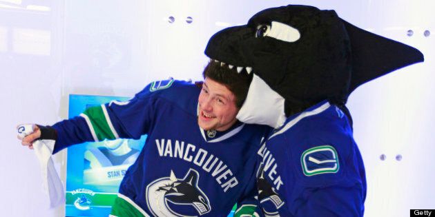 VANCOUVER, CANADA - DECEMBER 26: Cory Monteith, a Canadian actor from the television show 'Glee', jokes around with Vancouver Canucks mascot Fin before their game against the Edmonton Oilers at Rogers Arena on December 26, 2010 in Vancouver, British Columbia, Canada. (Photo by Jeff Vinnick/NHLI via Getty Images)