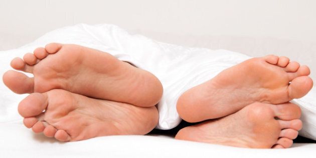 Dier feet of couple in bed. Separation and divorce