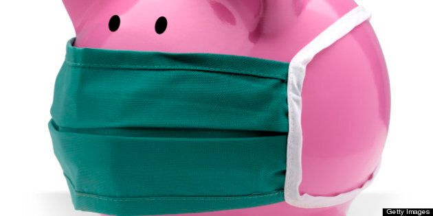 Pink piggy bank wearing a surgical mask to protect from infection.