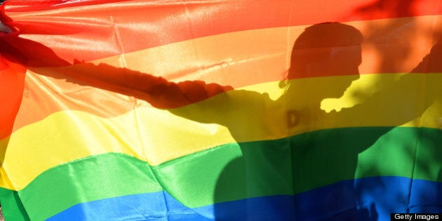 An activist's silhouette is seen through a rainbow flag during a Gay Parade in Kiev on May 25, 2013. Around a hundred gay rights activists marched in Ukraine on Saturday despite fears of violence and a court ban, marking the first gay pride event in the ex-Soviet country, where homophobia is widespread and generally accepted. AFP PHOTO/ SERGEI SUPINSKY (Photo credit should read SERGEI SUPINSKY/AFP/Getty Images)