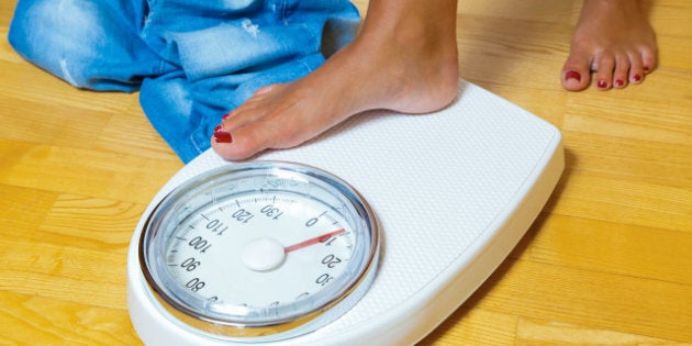 the feet of a woman standing on a bathroom scale