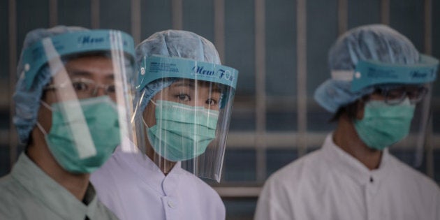 Officials are seen at the border with mainland China in Hong Kong on April 11, 2013 as authorities step up measures against the spread of the deadly H7N9 bird flu. The number of cases of the H7N9 strain of avian influenza rose to 33 in the mainland on April 10, with nine deaths since China announced that it had been found in humans for the first time. AFP PHOTO / Philippe Lopez (Photo credit should read PHILIPPE LOPEZ/AFP/Getty Images)